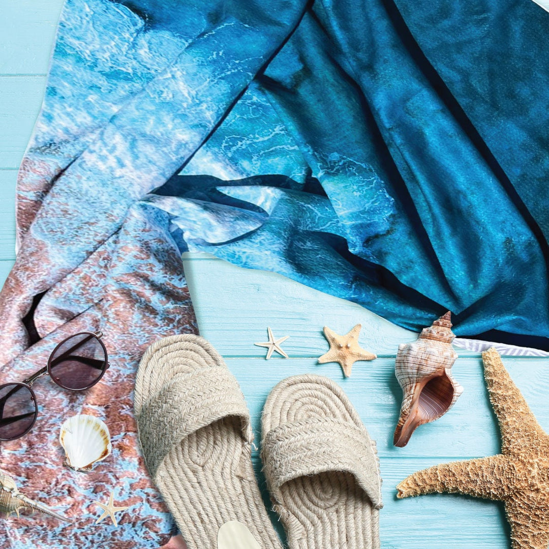 Beach accessories and shells with a Sand Free towel featuring beautiful beach image