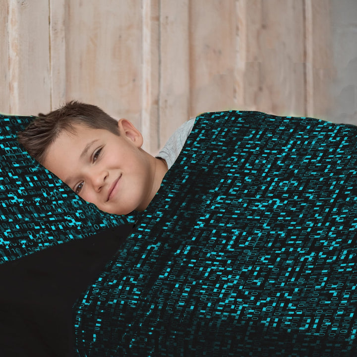 Young boy in calming sensory sheets with blue matrix computer coding print. 
