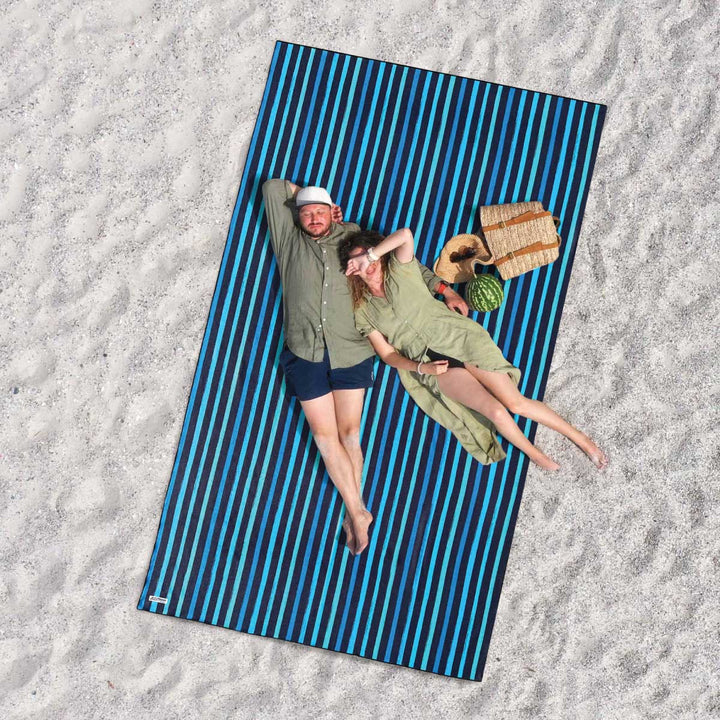 relaxed couple lounging on Bondi Teal jumbo Sand Free beach towel