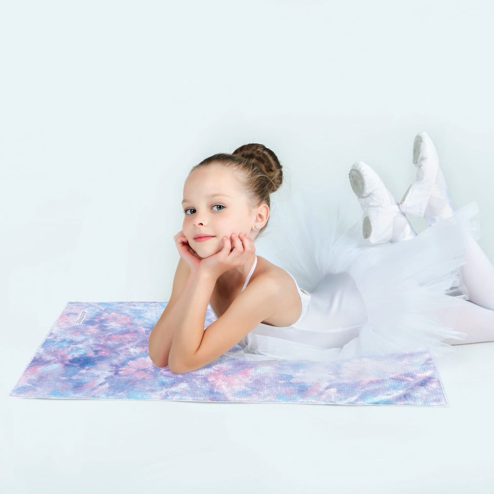 young ballet dancer laying on beautiful gym towel color with pastel pink, purple and blue