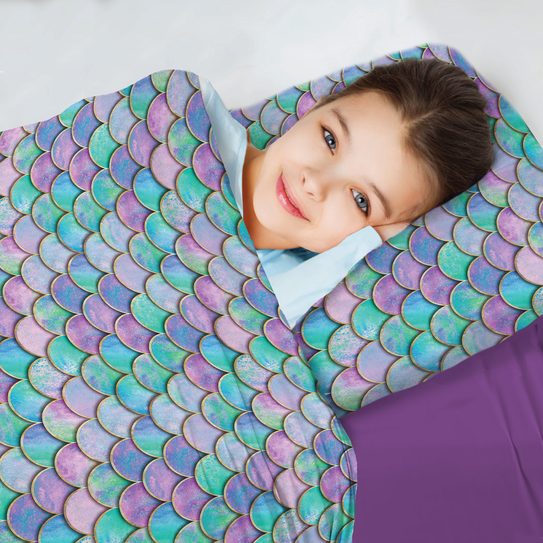 young girl tucked comfortably into  beautiful compression sheets with mermaid print