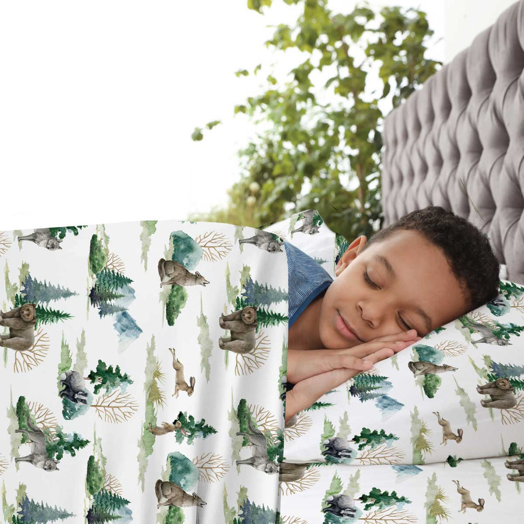 Young boy calm and asleep in JettProof compression sheets with American wildlife in neutral colors