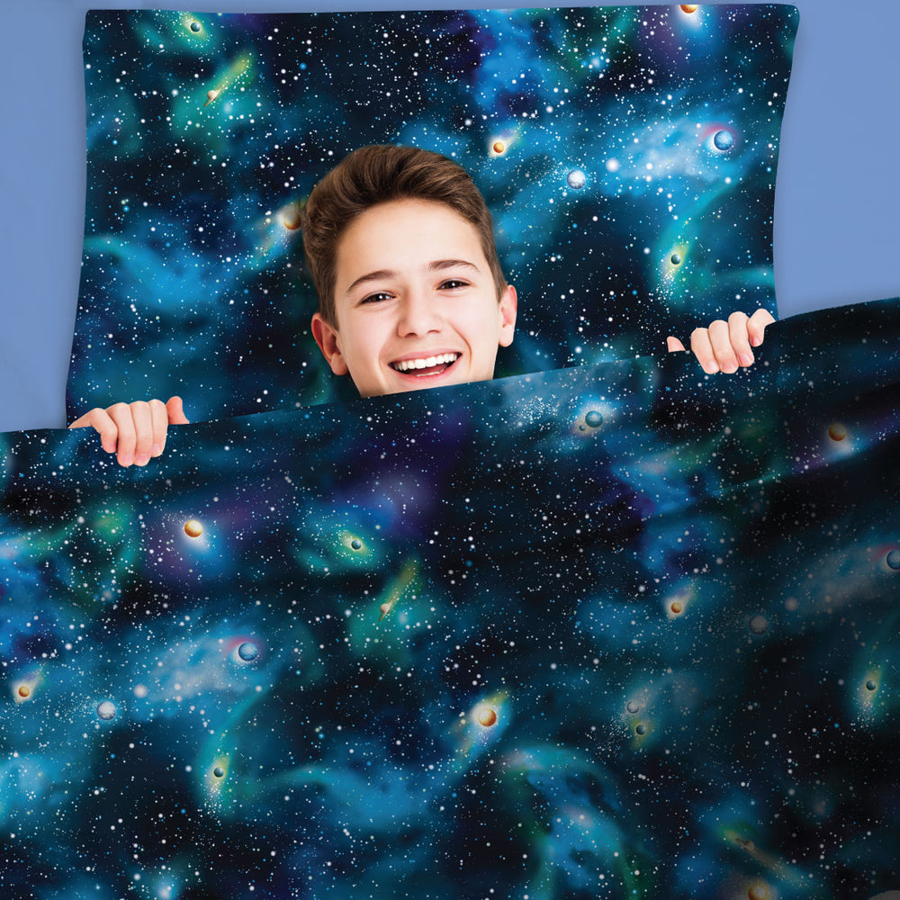 Happy young teen boy snug in JettProof Sensory compression sheets with beautiful universe pattern