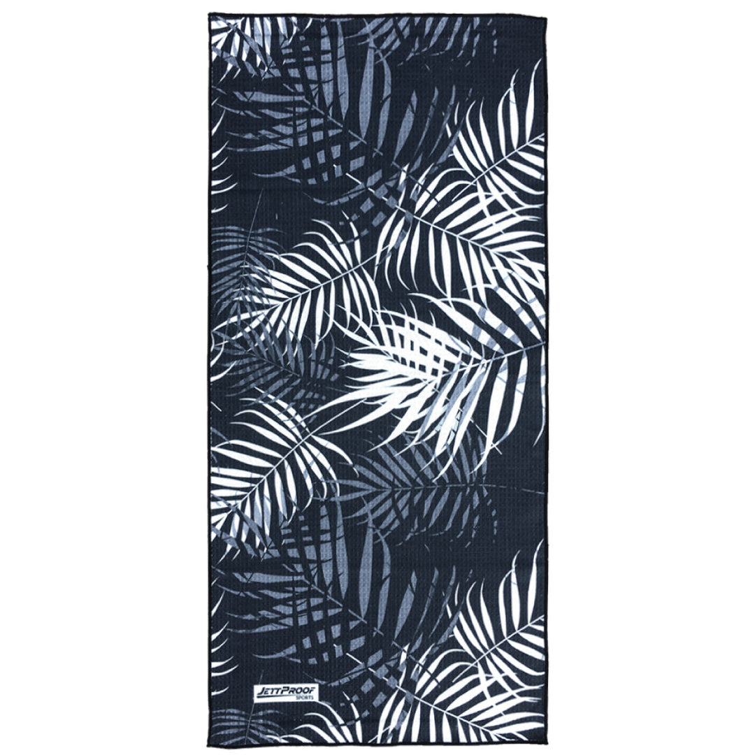 Black and white colored palm leaves on an antibacterial gym towel made from recycled fabric